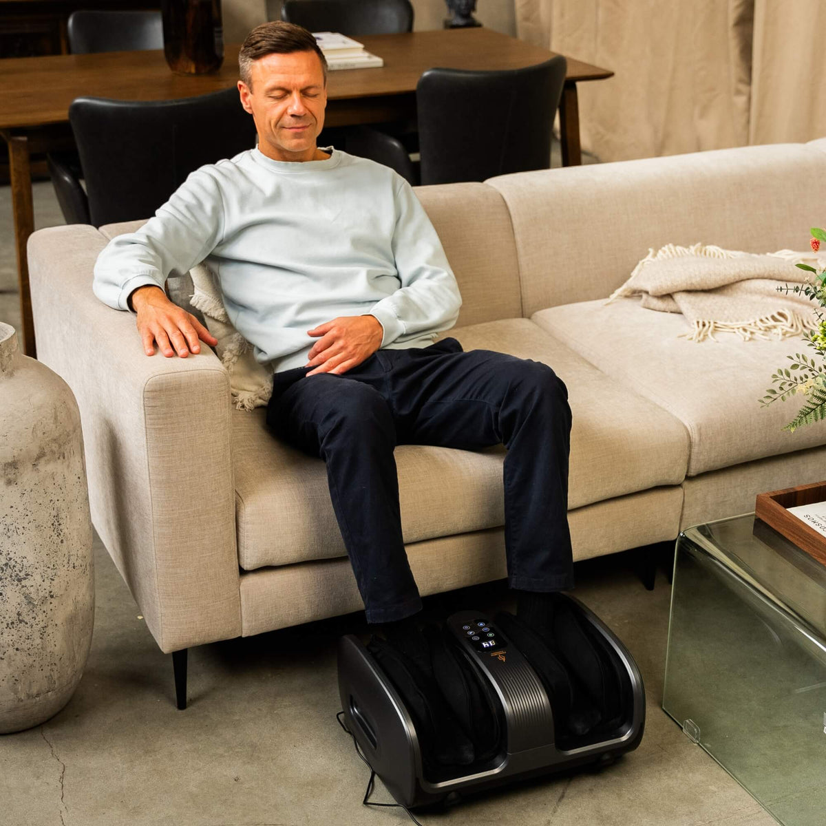 Mann slapper av i sofaen med Comforth FootCare Pro fotmassasjeapparat