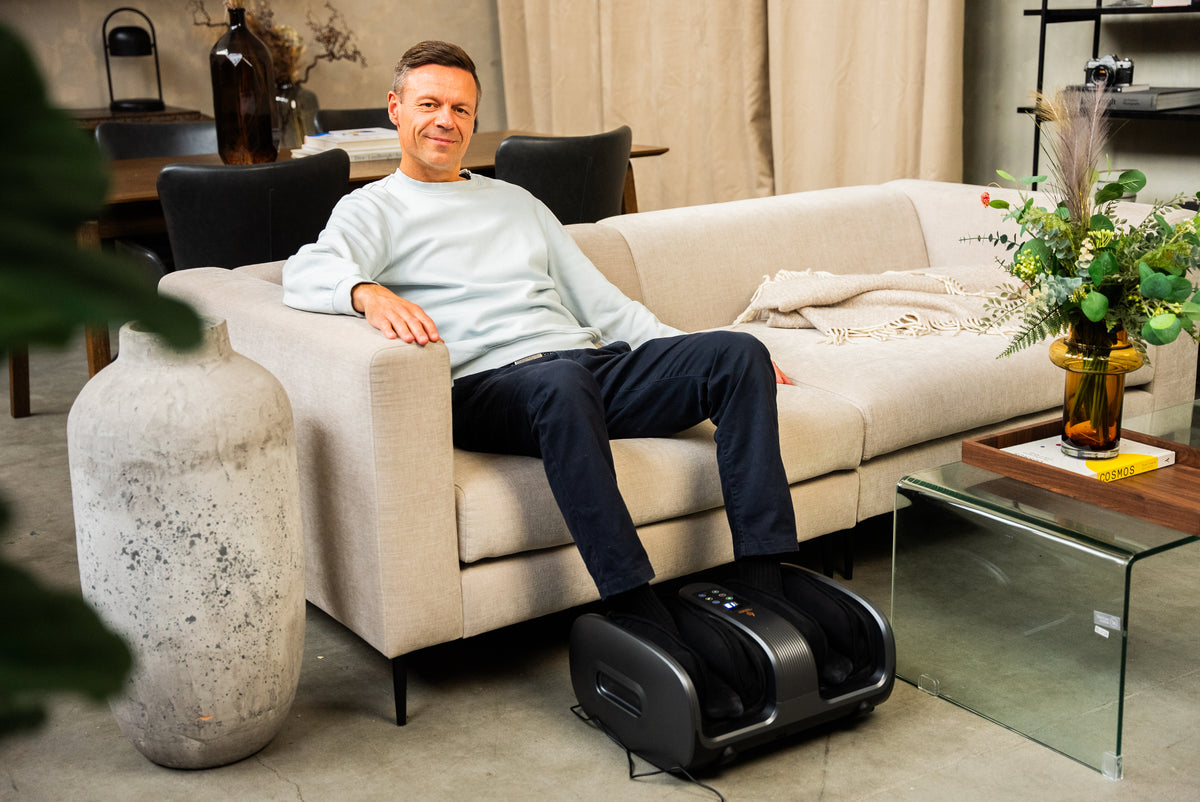Mann slapper av med Comforth FootCare Pro i sofaen