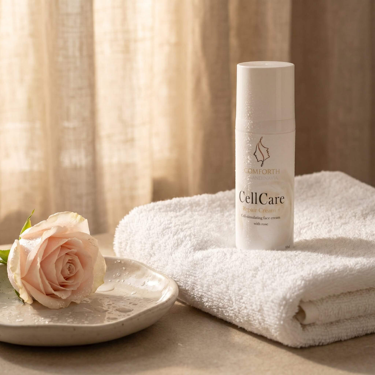 CellCare Repair Krem med villrose ved siden av håndkle og rose